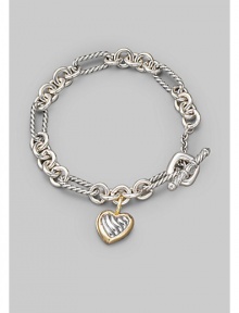 From the Cable Heart Collection. A bold chain, combining smooth and cable links, holds a lovely cable heart charm, framed in 18k gold. Sterling silver and 18k yellow gold Length, about 7½ Toggle closure Imported