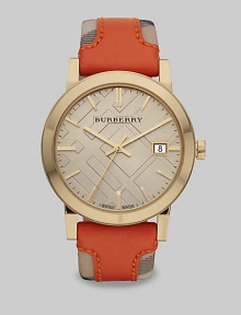 An iconic haymarket check strap with a pop of brilliant color in supple leather on a goldtone case. Quartz movementWater resistant to 5 ATMRound goldtone stainless steel case, 38mm (1.5)Smooth bezelLight trench check stamped dialBar hour markersDate display at 3 o'clockSecond hand Orange leather accented haymarket check strapMade in Switzerland An iconic haymarket check strap with a pop of brilliant color in supple leather on a goldtone case. Quartz movementWater resistant to 5 ATMRound goldtone stainless steel case, 38mm (1.5)Smooth bezelLight trench check stamped dialBar hour markersDate display at 3 o'clockSecond hand Orange leather accented haymarket check strapMade in Switzerland