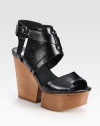 Supported by a wooden wedge and platform, this glazed leather essential has an unexpected cutout wedge, a rubber sole and adjustable criss-cross straps. Wooden wedge, 4 (100mm)Wooden platform, 1 (25mm)Compares to a 3 heel (75mm)Leather upperLeather liningRubber solePadded insoleImported