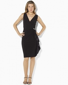 A flowing silk ruffle cascades down the skirt of an elegant sleeveless dress, accented with a shimmering broach at the waistline. A flowing silk ruffle cascades down the skirt of an elegant sleeveless dress, accented with a shimmering broach at the waistline.