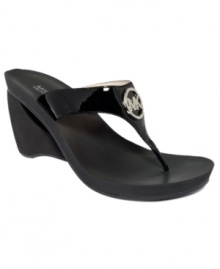 Smooth and shiny. MICHAEL by Michael Kors' Warren wedge sandals mold comfortably to your foot and feature a glimmering brand logo on top of the shiny patent straps. Smooth and shiny. MICHAEL by Michael Kors' Warren wedge sandals mold comfortably to your foot and feature a glimmering brand logo on top of the shiny patent straps.