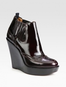 A stacked wedge heightens this patent leather ankle boot, with traditional perforated details and elasticized panels. Stacked wedge, 4¾ (120mm)Stacked platform, 1¼ (30mm)Compares to a 3½ heel (90mm)Patent leather upperPull-on style with side elastic panelsLeather liningRubber solePadded insoleMade in Italy