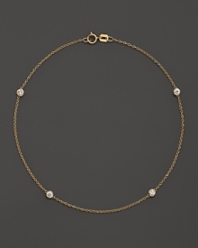 Diamond bezels sparkle from the stations on this dainty 14K yellow gold ankle bracelet. Diamond bezels sparkle from the stations on this dainty 14K yellow gold ankle bracelet.
