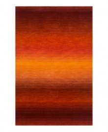 Imparting warm visions of brilliant sunrises on the horizon, this deeply textured rug features intense tones of red and orange that recall a perfect morning sky. Hand-tufted and color blended with the greatest of care, this wool rug comes alive with texture and color.